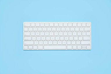 Açık mavi arkaplanda modern beyaz kablosuz klavye, üst görünüm