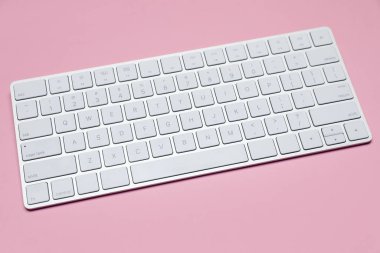 Pembe arka planda modern beyaz kablosuz klavye