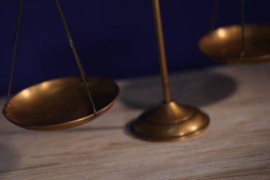 Adaletin terazisi ahşap masada, karanlık arka planda, yakın planda