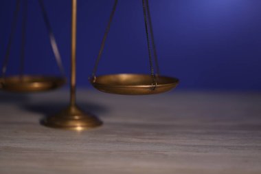 Adaletin terazisi ahşap masada, karanlık arka planda, yakın planda