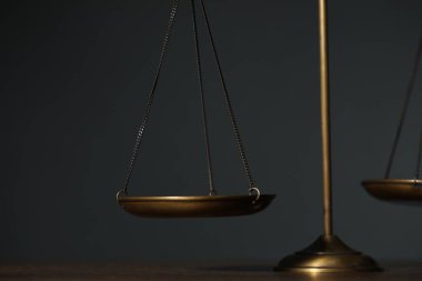 Masanın üzerindeki adalet terazileri gri arkaplanla, yakın plan