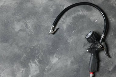 Gri arka planda göstergesi olan bir lastik enflasyon silahı. Metin için boşluk