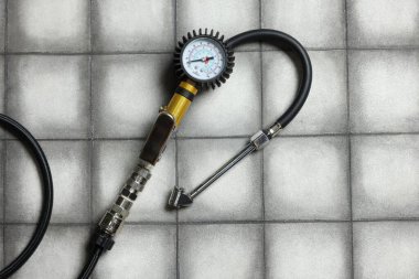 Işıklı arka planda göstergesi olan bir lastik enflasyon silahı, üst görünüm.