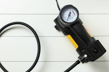 Beyaz ahşap arka planda modern bir lastik şişirici.