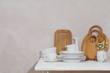 Temiz bulaşık takımları ve ışık duvarının yanındaki masada kesim tahtaları. Metin için boşluk