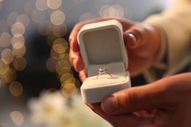 Evlenme teklif ediyorum. Nişan yüzüklü adam içeride, yakın plan. Bokeh etkisi