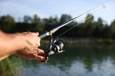 Yazın göl kenarında olta balıkçısı, yakın çekim.