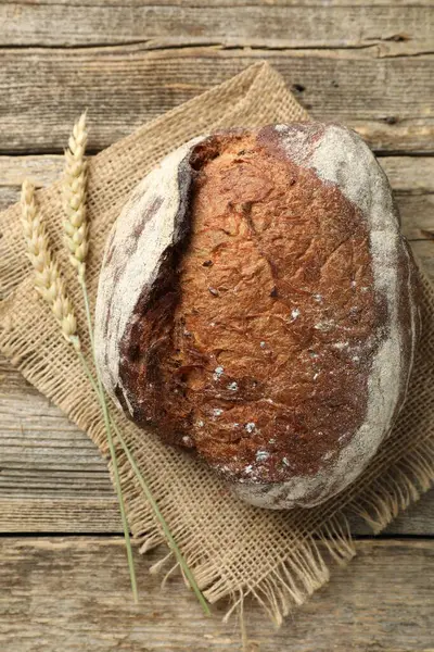 Bir somun taze ekmek ve çiviler ahşap masada, düz yatıyordu.