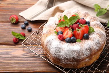 Tahta masada pudra şekeri ve böğürtlenli Lezzetli kek, yakın plan.