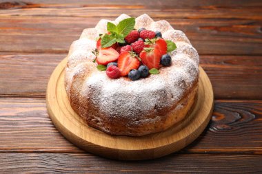 Tahta masada pudra şekeri ve böğürtlenli Lezzetli kek.