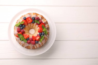 Böğürtlenli lezzetli kek, beyaz ahşap masa üzerinde şeker ve nane, üst manzara. Metin için boşluk