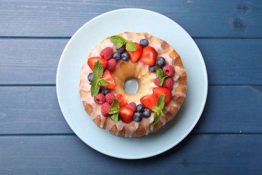 Böğürtlenli leziz kek, mavi ahşap masada jöle ve nane, üst manzara.