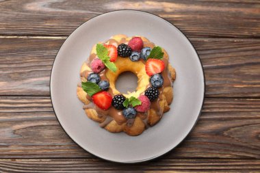 Böğürtlenli, çikolatalı ve nane şekerli, ahşap masa manzaralı Lezzetli kek.