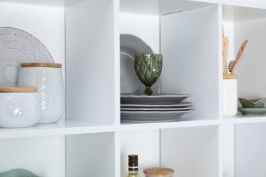 Farklı bulaşık takımları, cam ve diğer mutfak gereçleri olan raf ünitesi.