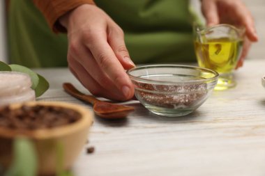 Beyaz ahşap masada doğal vücut ovuşturan kadın, yakın plan.