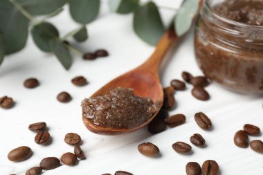 Doğal vücut fırçası, kahve çekirdekleri ve okaliptüs dalları beyaz ahşap masada, yakın plan.