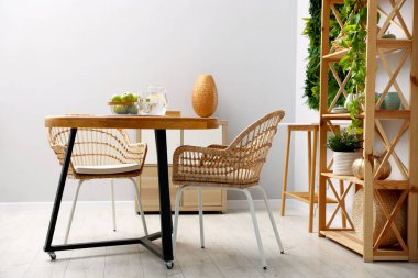 Şık yemek odasında sandalyeli ve dekorlu ahşap masa. İç tasarım