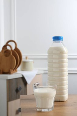 İçerideki ahşap masada şişe ve bir bardak süt.