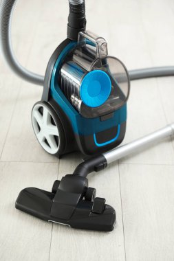 Tahta zeminde bir elektrikli süpürge. Ev aletleri