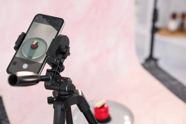 Stüdyoda akıllı telefonla lezzetli bir tatlı çekmek, seçici bir odak noktası. Profesyonel yemek fotoğrafçılığı.