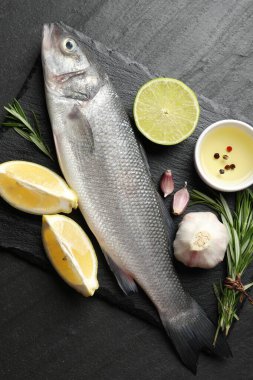 Siyah masadaki baharatlı taze çiğ deniz kabuğu. Balık ve deniz ürünleri lezzetleri