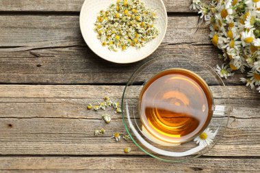 Cam bardakta Aromatik çay ve tahta masada papatya çiçeği. Metin için boşluk