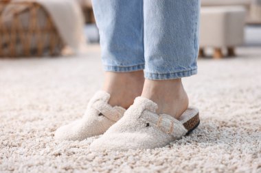Evdeki yumuşak halıda beyaz terlikli kadın, yakın plan.