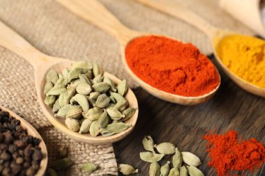 Masadaki kaşıklardaki farklı aromatik baharatlar, yakın plan.