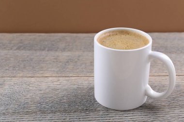 Kahverengi arka planda, ahşap masada, fincanda Aromatik kahve, yakın plan. Metin için boşluk