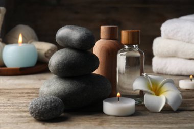 Kozmetik ürünleri ve spa taşlarıyla ahşap masaya yakın plan kompozisyon.