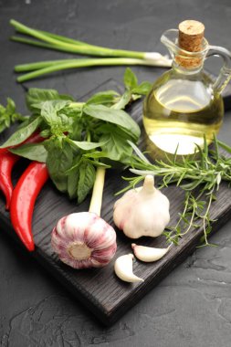 Siyah masada farklı taze otlar ve baharatlar, yakın plan.