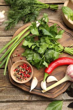 Farklı taze otlar ve baharatlar ahşap masada, düz yatıyordu.
