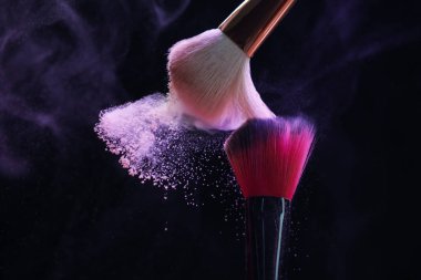 Siyah arka planda mor göz farlı makyaj fırçaları, yakın plan. Metin için boşluk