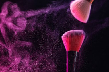 Siyah arka planda pembe göz farlı makyaj fırçaları, yakın plan. Metin için boşluk