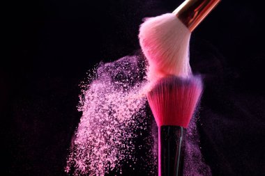 Siyah arka planda pembe göz farlı makyaj fırçaları, yakın plan. Metin için boşluk