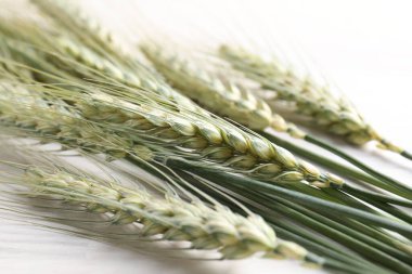 Açık ahşap masada bir sürü yeşil buğday çivisi, yakın plan.