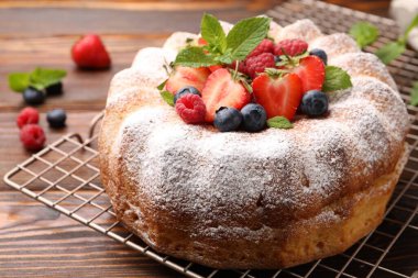 Tahta masada pudra şekeri ve böğürtlenli Lezzetli kek, yakın plan.