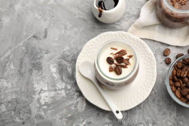 Çikolata parçalı lezzetli panna cotta ve kahve çekirdekleri gri desenli masada servis ediliyor. Metin için boşluk