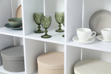 İçeride farklı bulaşık takımları, bardaklar ve bardaklar olan raf ünitesi