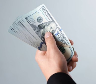 Arka planda dolar banknotları olan adam, yakın plan.