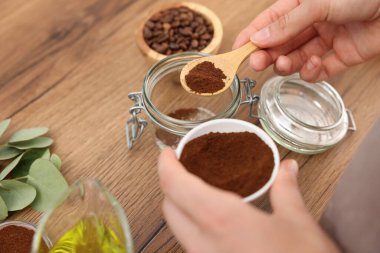 Doğal temizlik yapıyorum. Ahşap masada kahvesini kavanoza koyan kadın, yakın plan.