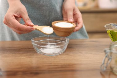 Doğal temizlik yapıyorum. Ahşap masada kaseye şeker koyan kadın, yakın plan.