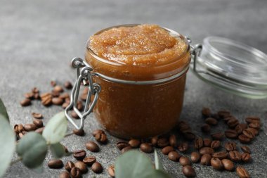 Cam kavanozda doğal vücut fırçası, kahve çekirdekleri ve okaliptüs dalları, yakın plan.