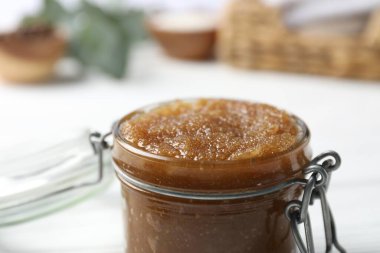 Bulanık arka planda cam kavanozda doğal vücut fırçası, yakın plan.