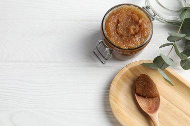 Doğal vücut fırçası ve okaliptüs dalları beyaz ahşap masa üzerinde, düz yerde. Metin için boşluk