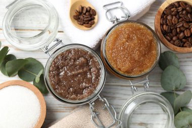 Cam kavanozlarda doğal vücut önlükleri ve ahşap masa üzerindeki malzemeler.