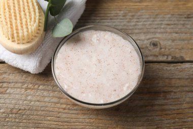 Doğal vücut ovma cam kase, fırça, havlu ve okaliptüs dalı ahşap masa, üst görünüm