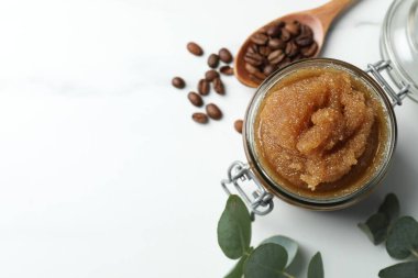 Doğal vücut fırçası, kahve çekirdekleri ve okaliptüs yaprakları beyaz masada, düz yerde. Metin için boşluk