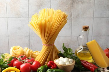 Masada farklı türde makarna ve malzemeler var, yakın plan.