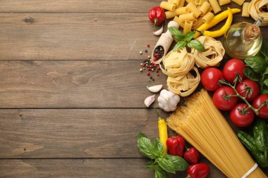 Farklı türde hamur makarnalar ve ahşap masa üzerindeki ürünler. Metin için boşluk